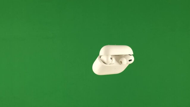 white wireless bluetooth headphones and case in front of green screen background changeable