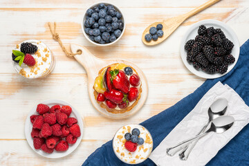 Sweet desserts with fresh berries on wooden background.