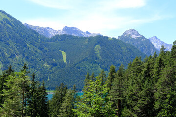 Scenic view green Alpine mountains and blue serene lake, mountain range in Europe, challenging...