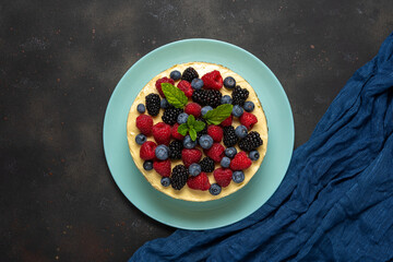 Homemade cake with fresh berries on dark background.