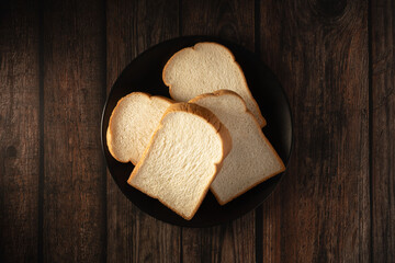 Simple Elegance: Slices of Soft White Bread on a Dark Plate, an Inviting Start to Any Meal or Snack...