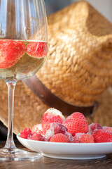 glass of wine and frozen red strawberries with ice close-up