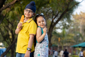 Group of kids having ice cream during summer camp .Kids having ice colorful ice candy enjoying summers