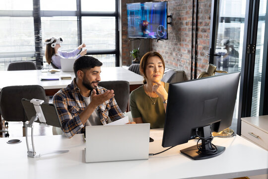 Asian male and female professionals are working at computers in a modern business office - Powered by Adobe