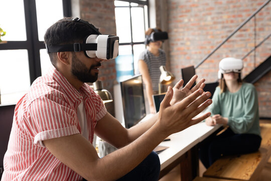 A diverse team is exploring virtual reality, wearing headsets in a modern business office