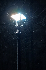 Close up outdoors shot of a street lamp turned on on winter cold night.