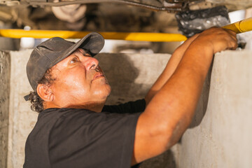 Mechanic in the repair area underneath a car