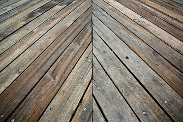New dark wooden floor slats for outdoor use with a diagonal course fixed with steel screws - obrazy, fototapety, plakaty