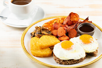 Fried eggs with sausages, nuggets, mushrooms and cup of coffee. Βreakfast concept.