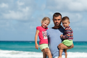 dad with children, playing with kids, family on the beach, swimming in the ocean, vacations in warm...