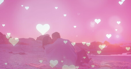 Image of hearts and light spots over diverse couple at beach
