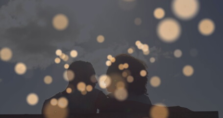 Image of light spots over african american couple at beach - Powered by Adobe
