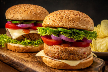 Two fresh tasty burgers on wooden rustic table. Food background.