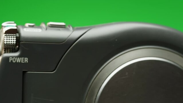 Vintage video-camera with disk inside rotating on green background close-up. Using portable camcorder to shooting videos
