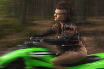 Stylish woman in a leather jacket, riding an ATV through a forest