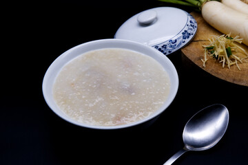 Porridge placed on a black background. Asian-style porridge. Rice porridge is one of the popular...