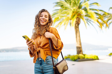 Young caucasian woman smiling happy using smartphone at the city.  Technology, blogging, travel,...