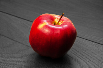 red ripe apple on a dark wooden background.	
