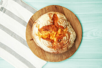 baked Italian bread on a light wooden table. ciabatta on a white towel on a wooden background	