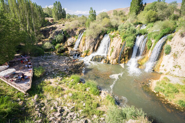 Beautiful mid size waterfalls with pool and people hanging around them and relaxing, Turkey