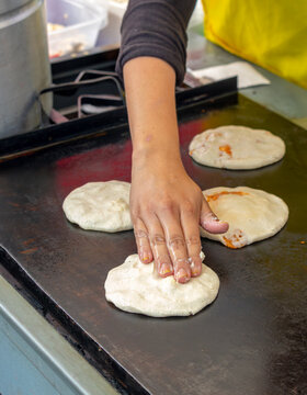 Persona cocinando pupusas una comida t&iacute;pica de El Salvador