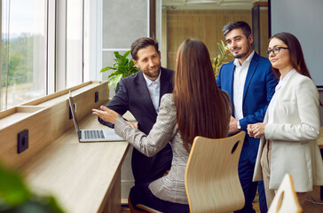 Dynamic group of business professionals converges for a work meeting in the office. This captivating image showcases the power of teamwork and effective team communication in a workplace setting. - obrazy, fototapety, plakaty