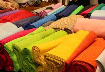 colorful cotton and felt fabrics for sale on the counter in the tailoring and drapery shop - 785639355