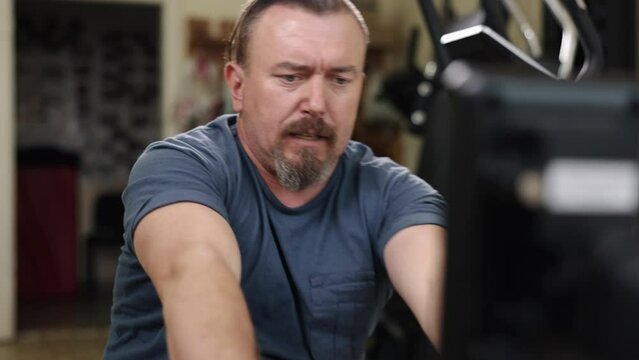 fitness exercise, Exercise limb, Rowing workout. Fitness enthusiast with prosthetic leg is training on rowing machine at gym.