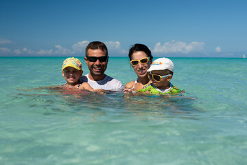 mom and dad with children, playing with kids, family on the beach, swimming in the ocean, vacations in warm countries, Caribbean sea, Atlantic ocean, Cuba, childhood, parents, daughter, son