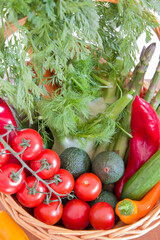 fresh assorted Vegetables in a basket on a wooden table, consumer vegetarian basket, tomatoes, fennel, paprika, asparagus,, cucumbers, avocado, Healthy eating concept, top view, High quality photo