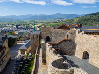 Vista del paisaje de León con las montañas verdes al fondo sobre montañas y cielo azul, desde el Castillo Templario medieval soleado, en verano de 2021 España.