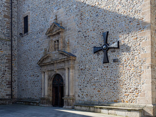 Puerta de entrada de la Basílica de la Virgen de la Encina y cruz templaria en la fachada de piedra, visita en León, España, verano de 2021