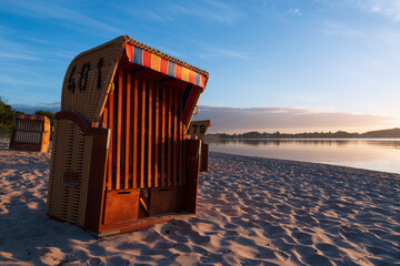 Strandkorb am Sandstrand in Eckernförde an der Ostsee.  - obrazy, fototapety, plakaty