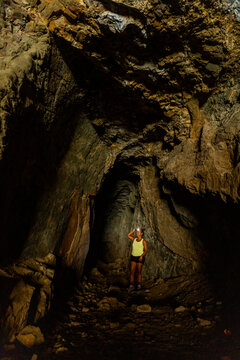 Explorer with headlamp standing in a dark cave