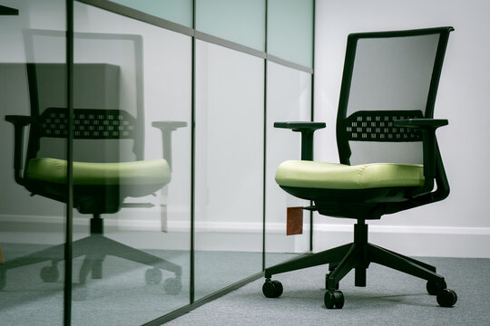 Modern office chair behind a transparent glass partition