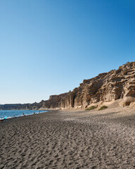 Vlychada beach on the southern tip of the island of Santorini with high white cliffs carved in particular shapes by the wind and the sea, gray sand mixed with pebbles