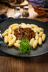 Beef stew in gravy, served with potato dumplings. - 785659963