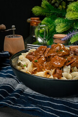 Pasta with beef stew in black bowl. - 785660303