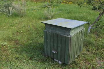 A hive of bees between in a field on a farm.