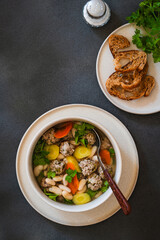 White bean beef meatball soup with  seasonal vegetables on grey background, directly abiove - 785666503