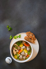 White bean beef meatball soup with  seasonal vegetables on grey background, directly abiove - 785666557