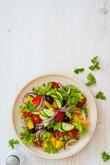 Plate of fresh salad with vegetables on white wood rustic background