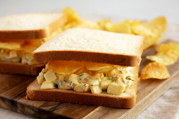 Homemade Egg Salad Sandwich with Potato Chips on a wooden board, side view. Close-up. - 785668127