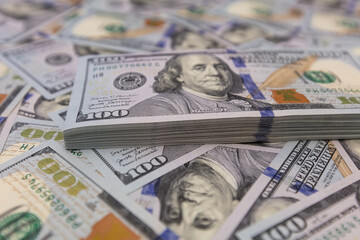 Pile of US 100 dollar banknotes on dollars background