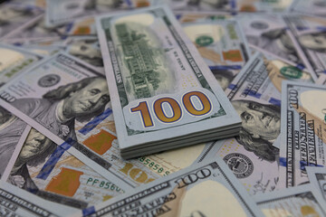 Pile of US 100 dollar banknotes on dollars background