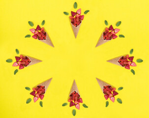 Ice cream cone with strawberry on the yellow background. Copy space. Top view.
