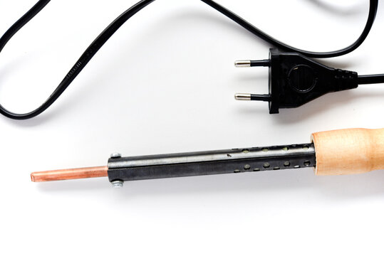 Electric soldering iron with a wooden handle on a white background. A tool for soldering radio components.