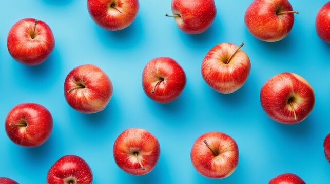 A vibrant pattern of fresh red apples arranged neatly on a blue background, creating a visually appealing display