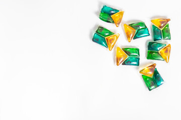 Yellow and green washing capsules on white background. Frame made of washing capsules. Free space...