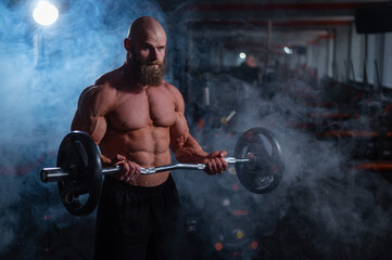 Fototapeta na wymiar Caucasian bald topless man doing an exercise with a barbell in the gym. Bicep curls with weights.